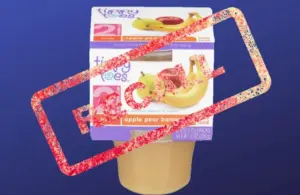 A pack of apple pear banana baby food against a blue background, marked with a bold red "RECALL" stamp, indicating a safety alert.
