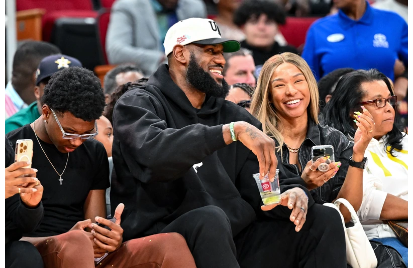 Mar 28, 2023; Houston, TX, USA; Los Angeles Laker LeBron James and his wife Savannah James sit court side at the McDonald's All American game during the first half at Toyota Center. Mandatory Credit: Maria Lysaker-Imagn Images