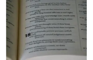 Open book showing a passage with numbered verses. Verse 18 appears bold, discussing themes of wisdom, restraint, and understanding. Calm tone. the ten commandments