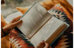 Person reading a book (possibly one of the best sellers)