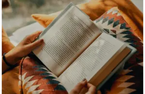 Person reading a book (possibly one of the best sellers)