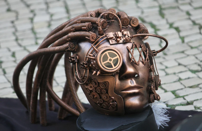 A steampunk sculpture of a human head in a collection of copper gears, wires and pipes.