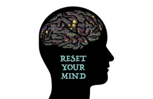 Silhouette of a head filled with positive words like "value" and "trust" in vibrant colors. Below, the text reads "Reset Your Mind" in light blue for visualization.