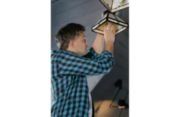A person fixing a lamp in his home