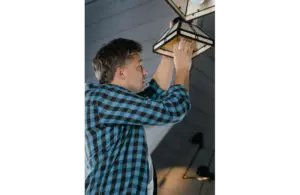 A person fixing a lamp in his home
