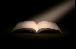 In daily devotion, a Bible has a light shining down on it.