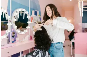 a girl performing a haircut in a salon