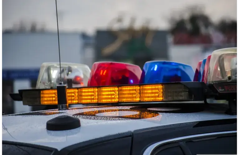 Police lights of orange, red, white and blue on top of an unmarked car with an antenna. Erie Pennsylvania mass shooting