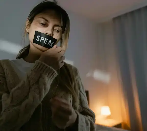 A woman removing the black tape on her lips, similar to the Turpin family case