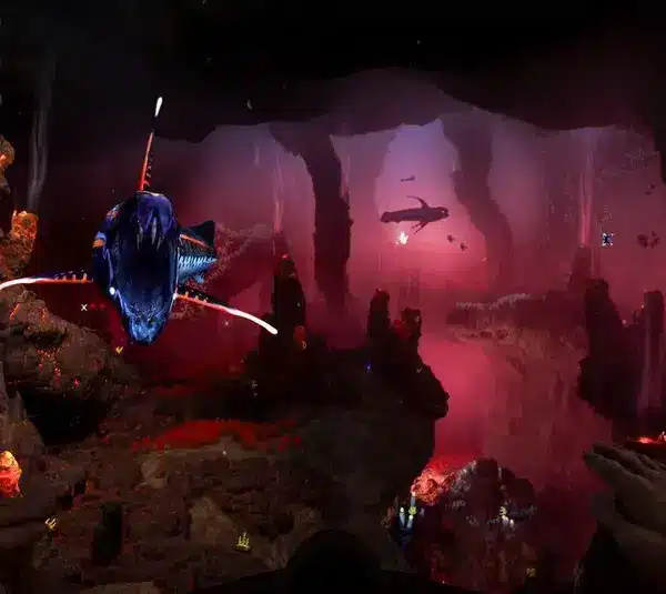 A vibrant underwater scene with bioluminescent sea creatures, glowing coral, and deep red hues. A diver's hands frame the view, conveying exploration. Subnautica 2, Krafton