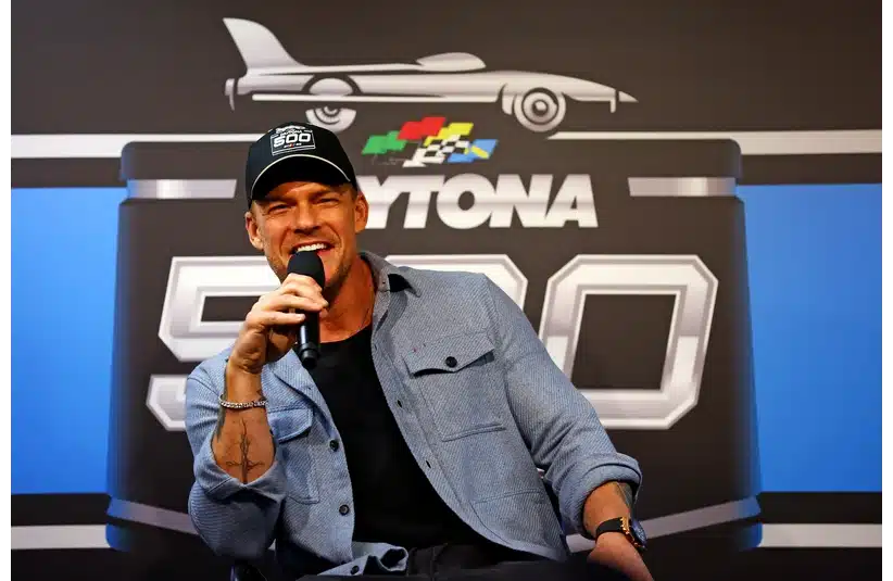 Feb 16, 2025; Daytona Beach, Florida, USA; American actor Alan Ritchson speaks during a press conference before the Daytona 500 at Daytona International Speedway. Mandatory Credit: Peter Casey-Imagn Images