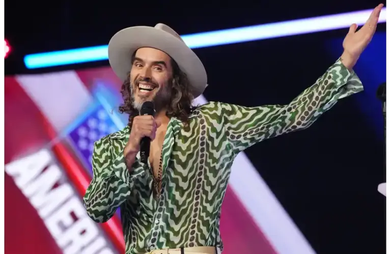 Russell Brand takes the stage during AmericaFest at the Phoenix Convention Center on Dec. 18, 2025. © Joe Rondone/The Republic / USA TODAY NETWORK via Imagn Images