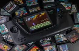 A pile of retro games on a table with a retro handheld game. Myrient