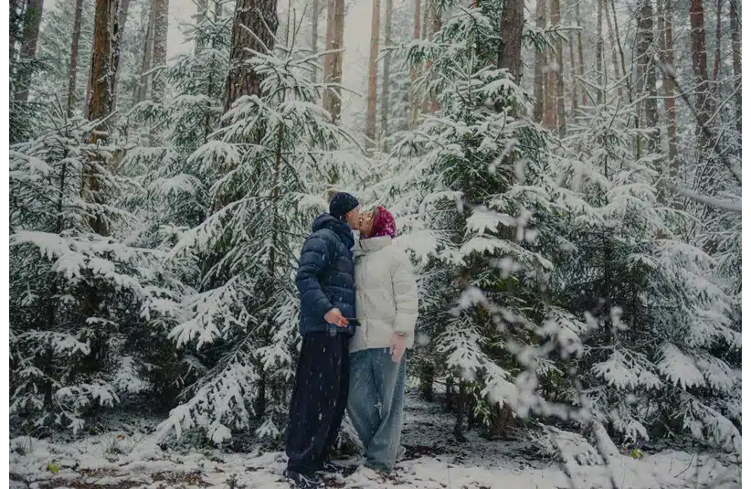 A couple enjoying fresh snow in the forest