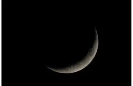 A crescent moon set against a black sky, showcasing detailed surface textures. The scene is serene and evokes a sense of calm and wonder.