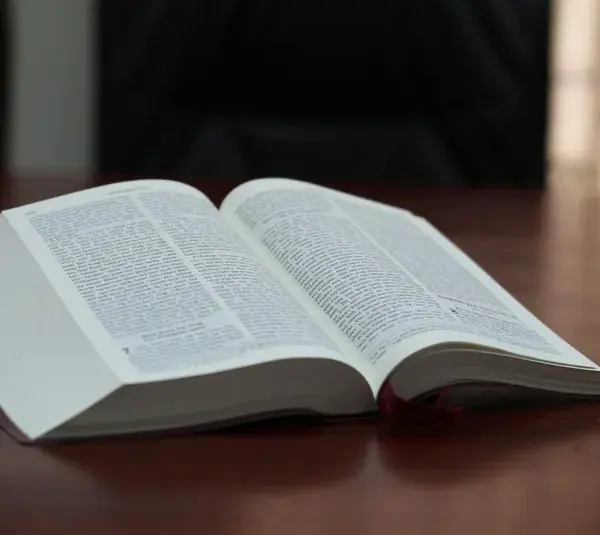 In daily devotion, open Bible sits on desk.