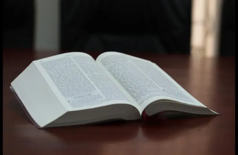 In daily devotion, open Bible sits on desk.