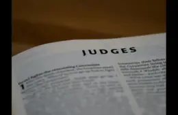 In daily devotion, a Bible is open to Judges.