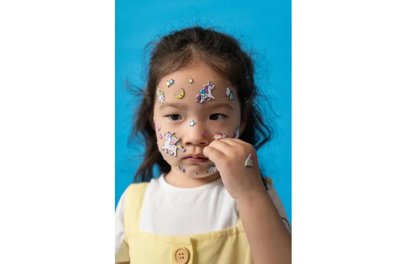 A child with cute stickers all over her face