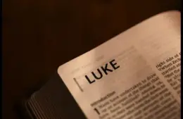 In the triumphal entry story, an open Bible displays Luke.