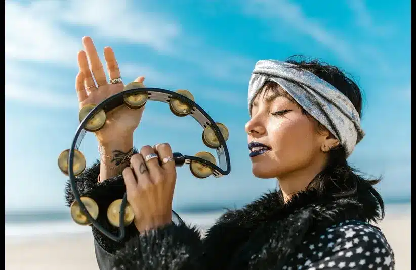 In daily devotion, a woman plays a tamborine.