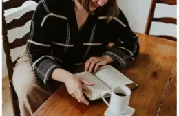 A woman reading a book in honor celebrating female authors for Women's History Month