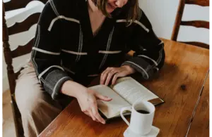 A woman reading a book in honor celebrating female authors for Women's History Month