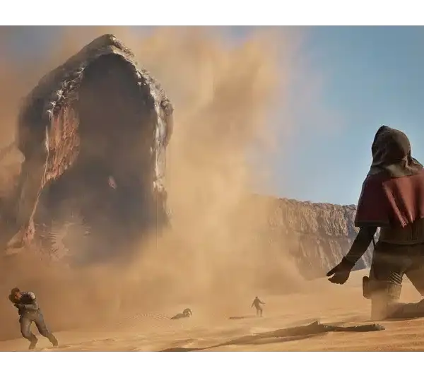 A massive sand worm emerges from the desert in Dune: Awakening, creating a dust storm. People in cloaks flee in fear under a clear blue sky, conveying urgency and danger.