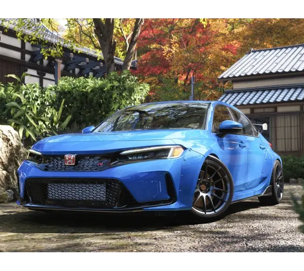 Forza Horizon 6 a Blue sporty car parked in a tranquil Japanese garden with stone path, lush greenery, and a traditional building. Vibrant autumn leaves enhance the serene setting.