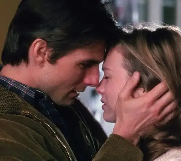 Jerry Maguire and Dorothy Boyd embrace tenderly, foreheads touching, eyes closed. The man gently holds her face, conveying a deep emotional connection and warmth.