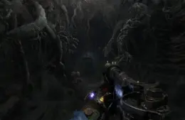 A first-person view in a dark, eerie tunnel filled with twisted roots in Metro Exodus. The scene is tense, with a gun aiming forward, illuminated by dim light. Metro 4