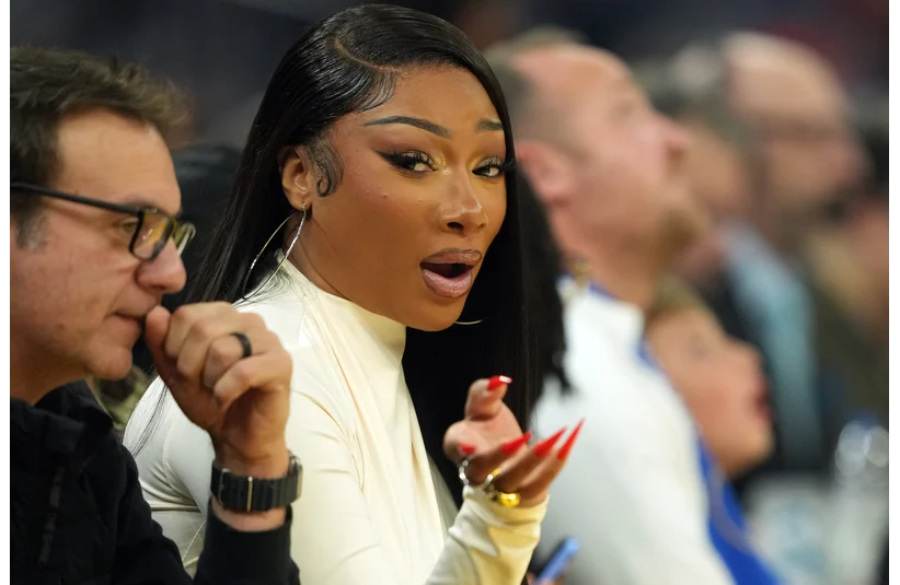 Dec 25, 2025; San Francisco, California, USA; Recording artist Megan Thee Stallion (center left) sits courtside during the first quarter of the game between the Golden State Warriors and the Dallas Mavericks at Chase Center. Mandatory Credit: Darren Yamashita-Imagn Images