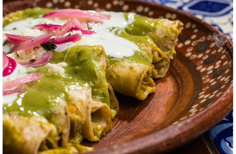Chicken enchilladas with a vibrant green salsa verde on top