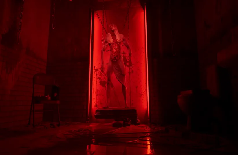 a naked body, with the upper body torn in half displayed with chains protruding from the body in Hellraiser: Revival 
