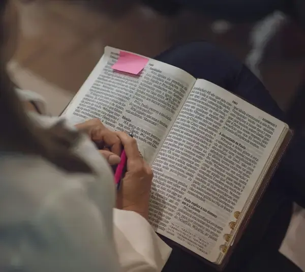 In this daily devotional, a lady reads the Bible on her lap.