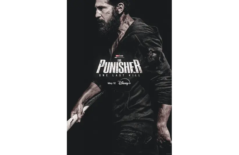 Dark poster of "The Punisher: One Last Kill." A bearded man in a hoodie grips a baseball bat, conveying intensity. Debuts May 12 on Disney.