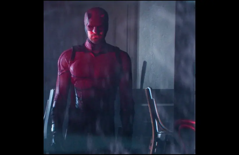 Daredevil stands in a dimly lit room, appearing focused and determined. The setting conveys a mysterious and intense atmosphere.