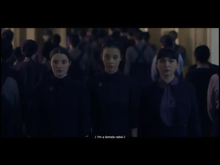 Screenshot from "The Testaments" showing Lucy Halliday, Chase Infiniti, and Rowan Blanchar
