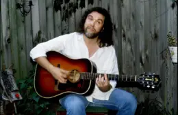 Nashville's Dennis Locorriere relaxes with his guitar outside his Oak Hill bungalow Aug. 29, 1990. The former Dr. Hook lead vocalist has been writing songs and singing jingles, trying to stay out of the limelight while he raised his son.