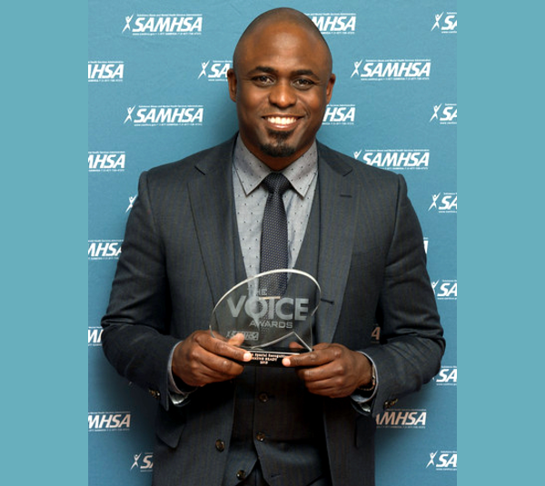 Wayne Brady holds his 2015 SAMHSA Special Recognition Award