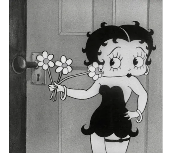 black and white shot of Bebby Boop in a black dress and holding flowers.
