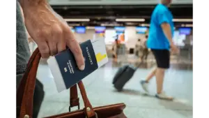 A person walking through an airport carrying luggage and a passport. Ebola outbreak, travel restriction