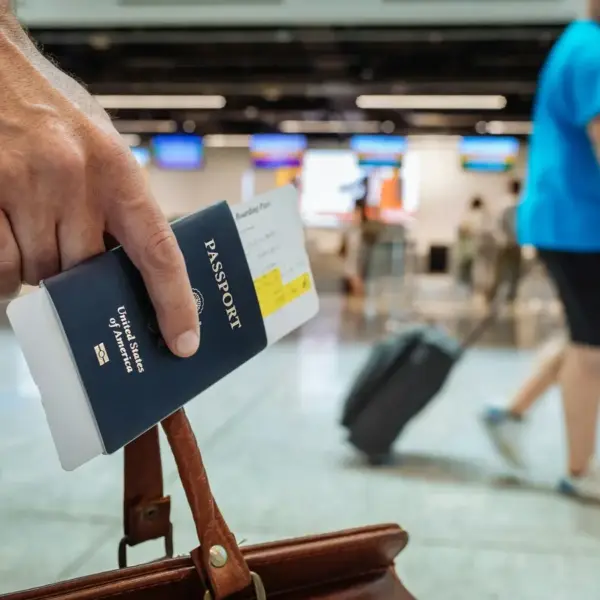 A person walking through an airport carrying luggage and a passport. Ebola outbreak, travel restriction