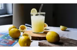 Lemon trend Freshly made in a glass with lemons on a rustic table. Perfect refreshment