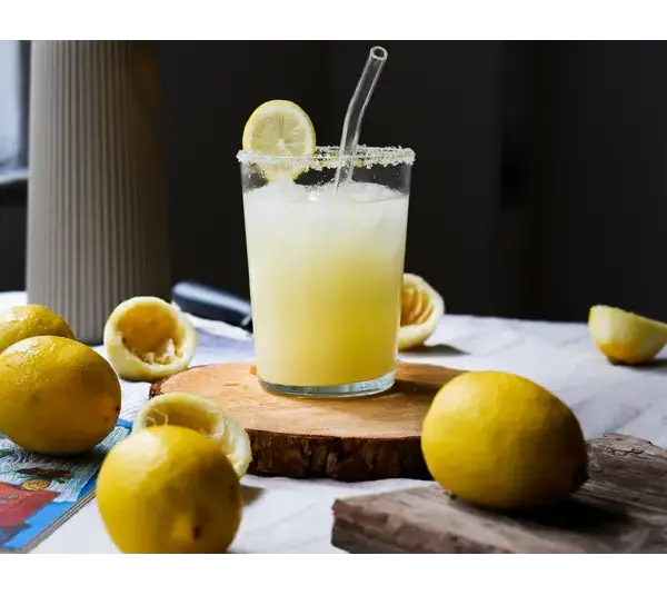Lemon trend Freshly made in a glass with lemons on a rustic table. Perfect refreshment