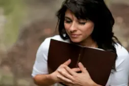 In daily devotional, a woman embraces her Bible.