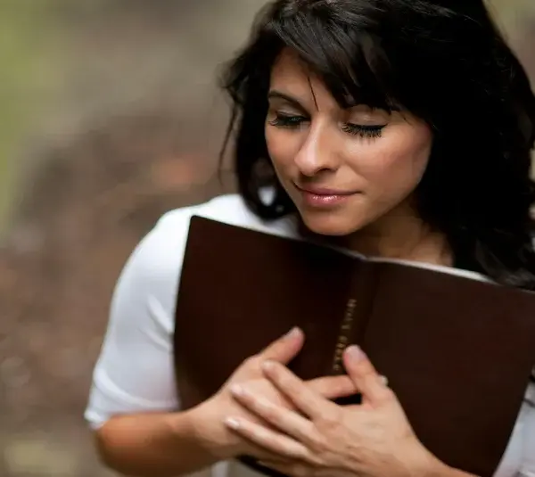 In daily devotional, a woman embraces her Bible.