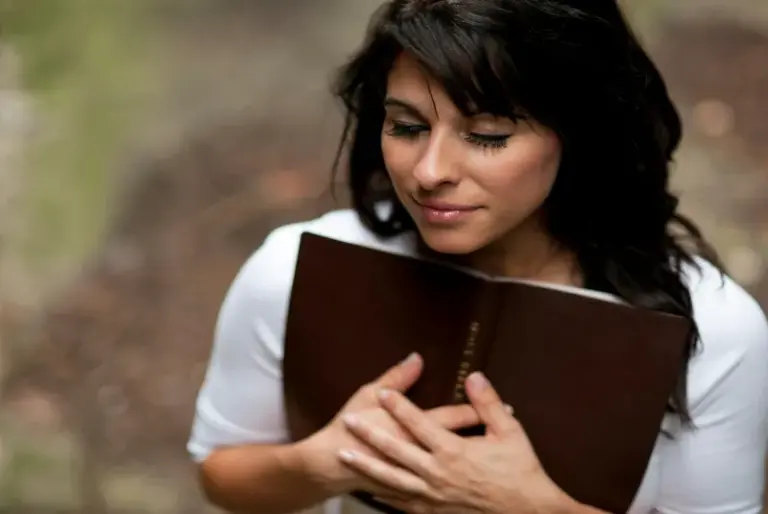 In daily devotional, a woman embraces her Bible.