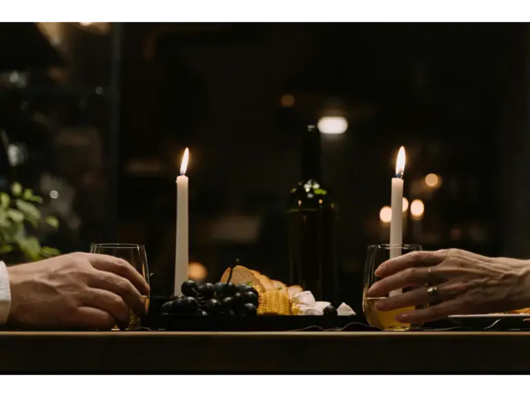 Intimate candlelit dinners featuring wine, cheese, and glowing candles arranged beautifully on a rustic wooden table.
