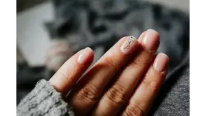 Close-up of a woman's elegant natural nails featuring a jellyfish design on soft pastel nails